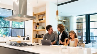 family in kitchen with laptop