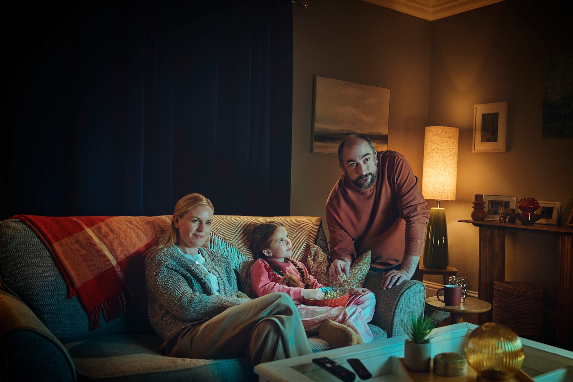 Family watching television in the living room