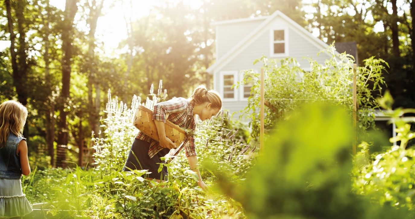 Woman in a garden with girl and a bag